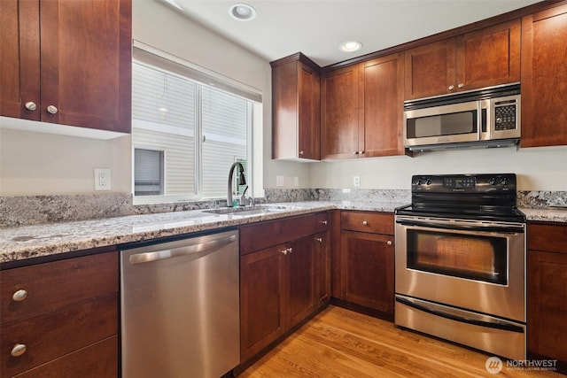 9211 Ashworth Ave N Unit B, Seattle, WA 98103 - kitchen with stainless steel appliances, light wood-style flooring, light stone counters, and recessed lighting