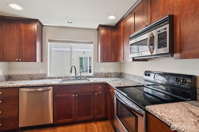 9211 Ashworth Ave N Unit B, Seattle, WA 98103 - kitchen with appliances with stainless steel finishes, light stone counters, recessed lighting, and light wood finished floors