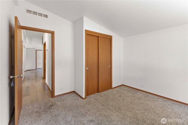 12407 Prairie Ridge Dr E, Bonney Lake, WA 98391 - unfurnished bedroom featuring lofted ceiling, carpet floors, and a closet
