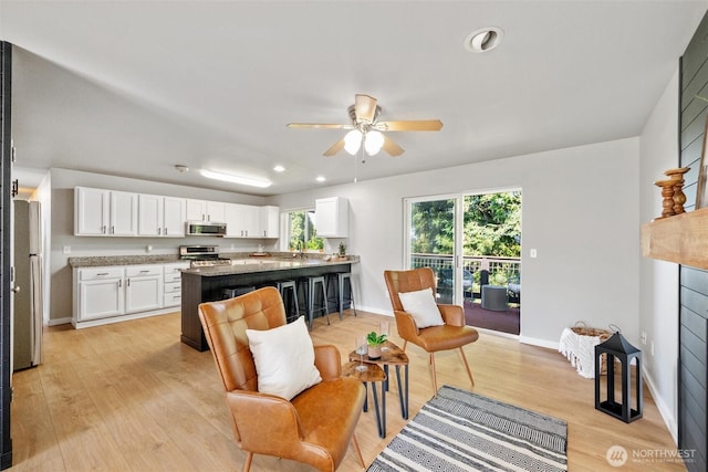 2141 Jason Ct, Ferndale, WA 98248 - kitchen featuring appliances with stainless steel finishes, white cabinets, a peninsula, light wood-style flooring, and a ceiling fan