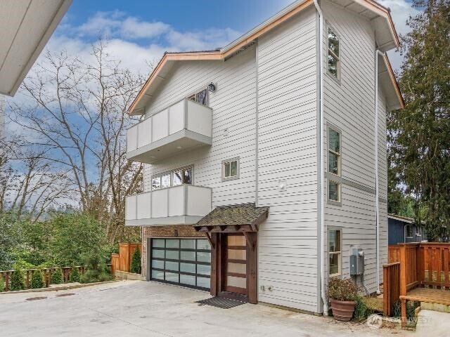 13716 30th Ave NE Unit B, Seattle, WA 98125 - view of side of property featuring a balcony, a garage, and concrete driveway
