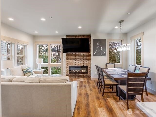 13716 30th Ave NE Unit B, Seattle, WA 98125 - living room featuring wood finished floors, a brick fireplace, recessed lighting, and a chandelier