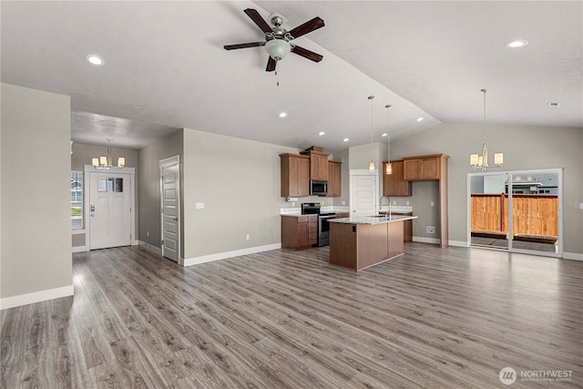 832 Q St SW, Quincy, WA 98848 - kitchen featuring open floor plan, stainless steel appliances, a chandelier, an island with sink, and light wood finished floors