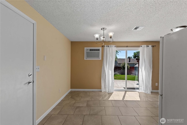 1315 Gaspar St, Wenatchee, WA 98801 - unfurnished dining area with a wall mounted air conditioner, a chandelier, a textured ceiling, and tile patterned floors