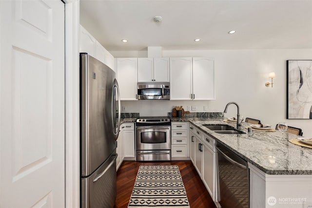 10909 Avondale Rd NE Unit L145, Redmond, WA 98052 - kitchen featuring stainless steel appliances, a peninsula, stone countertops, white cabinets, and dark wood-style flooring