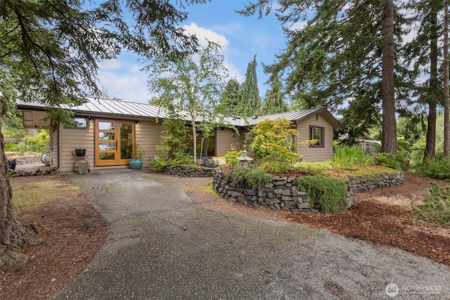 1201 Wilson St, Port Townsend, WA 98368 - view of front of home featuring a standing seam roof, asphalt driveway, and a metal roof