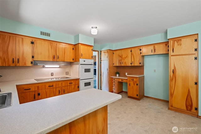 386 Mocliff Rd, Ephrata, WA 98823 - kitchen with double oven, light countertops, a peninsula, and black electric stovetop