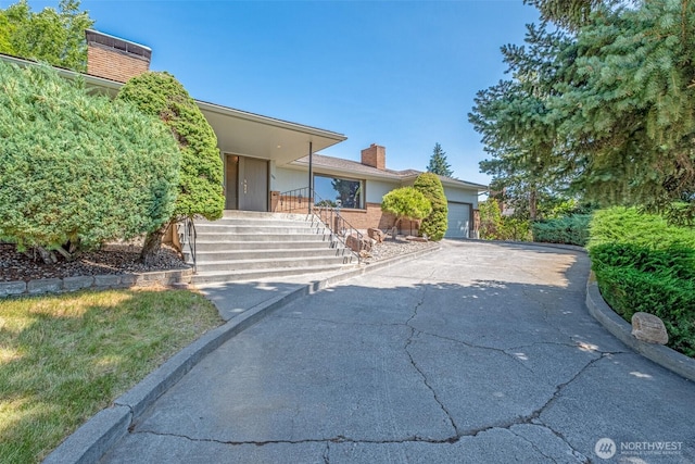 386 Mocliff Rd, Ephrata, WA 98823 - mid-century inspired home with a chimney, a garage, driveway, and brick siding