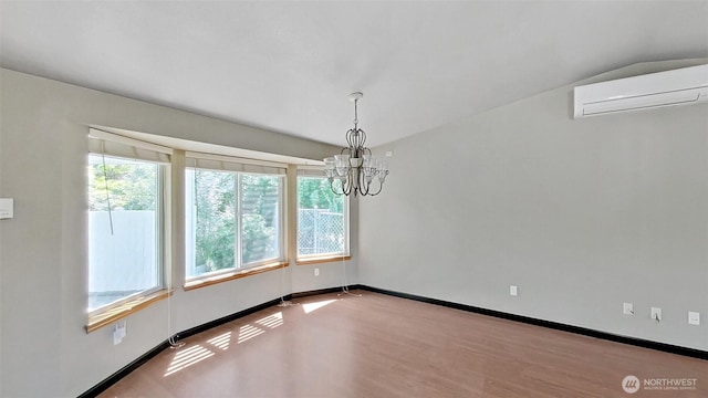 24250 164th Ave SE, Kent, WA 98042 - unfurnished room featuring an AC wall unit, plenty of natural light, a chandelier, and wood finished floors