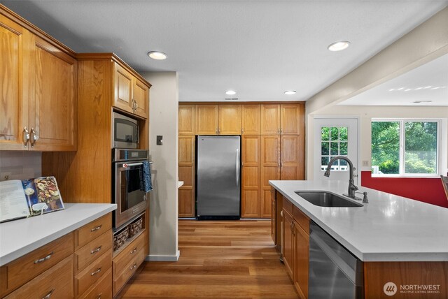 12012 County Line Rd E, Edgewood, WA 98372 - kitchen featuring appliances with stainless steel finishes, light wood-style flooring, light countertops, brown cabinets, and recessed lighting
