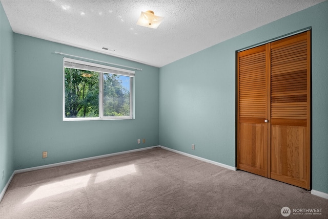 12012 County Line Rd E, Edgewood, WA 98372 - unfurnished bedroom with carpet, a closet, and a textured ceiling