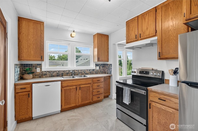 2318 F St, Bellingham, WA 98225 - kitchen with appliances with stainless steel finishes, under cabinet range hood, healthy amount of natural light, and tasteful backsplash