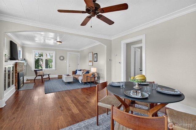 2318 F St, Bellingham, WA 98225 - dining room with arched walkways, wood finished floors, ornamental molding, a brick fireplace, and a ceiling fan