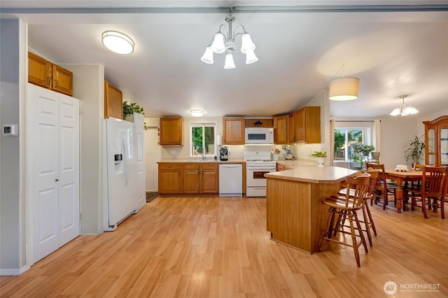 24442 Wicker Rd Unit 37, Sedro Woolley, WA 98284 - kitchen with a chandelier, white appliances, a peninsula, light countertops, and light wood-style floors