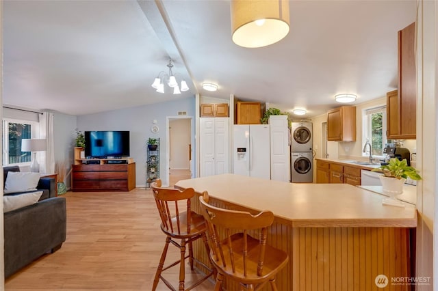 24442 Wicker Rd Unit 37, Sedro Woolley, WA 98284 - kitchen with white fridge with ice dispenser, open floor plan, stacked washer / dryer, a peninsula, and light wood-type flooring