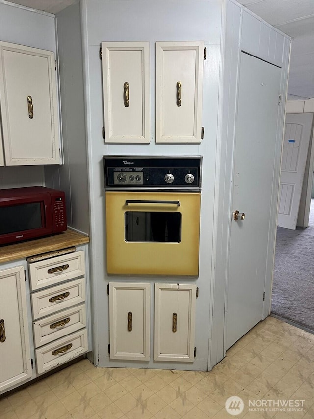 1411 Kellogg Hallow Rd, Dayton, WA 99328 - kitchen with oven, light flooring, white cabinetry, and light carpet