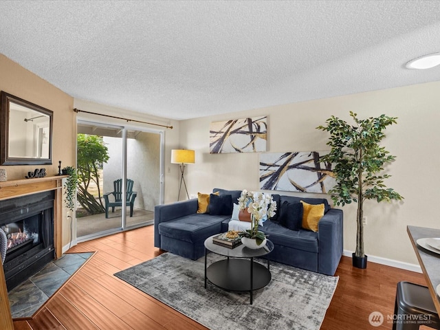 4811 76th St NE Unit 5, Marysville, WA 98270 - living room with a textured ceiling, a fireplace with flush hearth, and wood finished floors