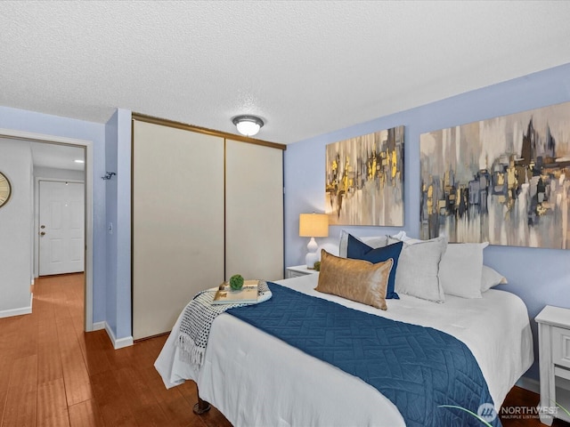 4811 76th St NE Unit 5, Marysville, WA 98270 - bedroom with wood finished floors, a closet, and a textured ceiling