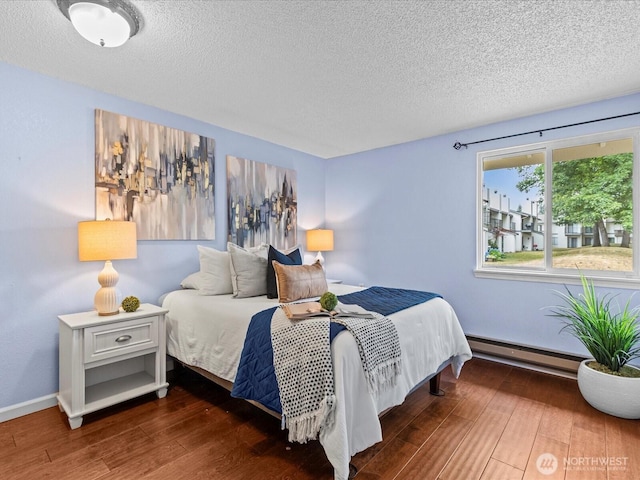 4811 76th St NE Unit 5, Marysville, WA 98270 - bedroom with a baseboard radiator, a textured ceiling, and wood finished floors