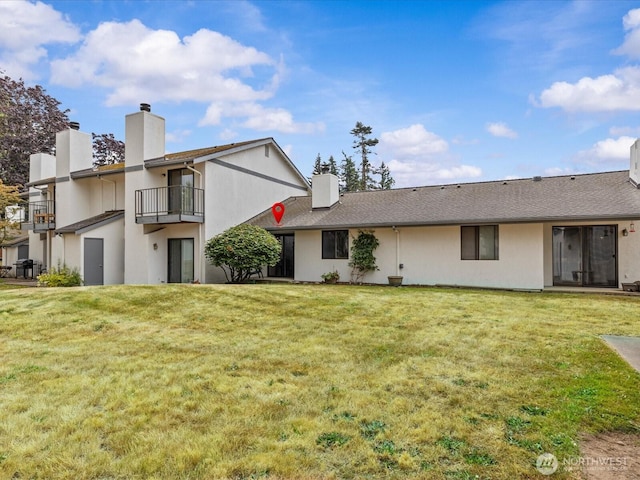 4811 76th St NE Unit 5, Marysville, WA 98270 - rear view of property featuring a chimney, a balcony, a yard, and stucco siding