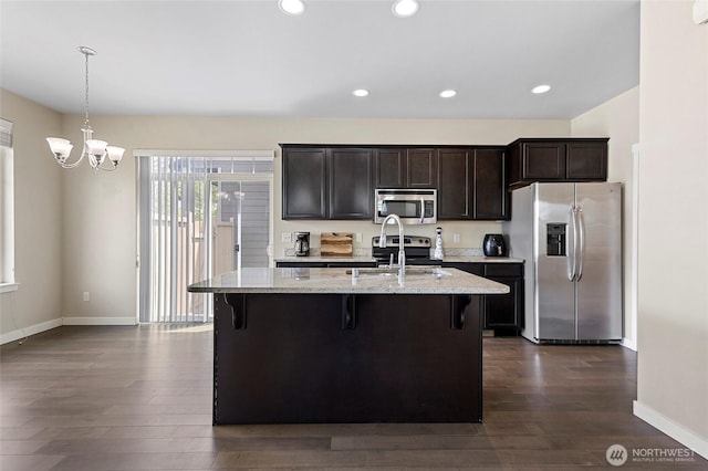 329 Holland Ave, Bellingham, WA 98226 - kitchen featuring stainless steel appliances, a kitchen bar, dark wood-style flooring, a center island with sink, and recessed lighting
