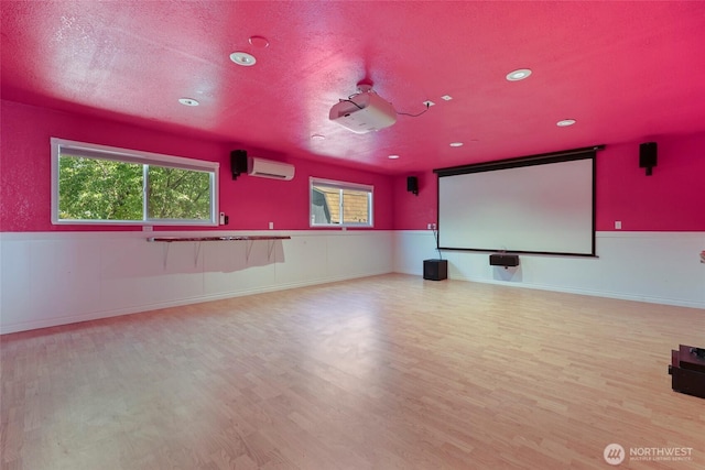 11636 25th Ave SE, Olympia, WA 98513 - home theater room featuring an AC wall unit, wood finished floors, recessed lighting, and a textured ceiling