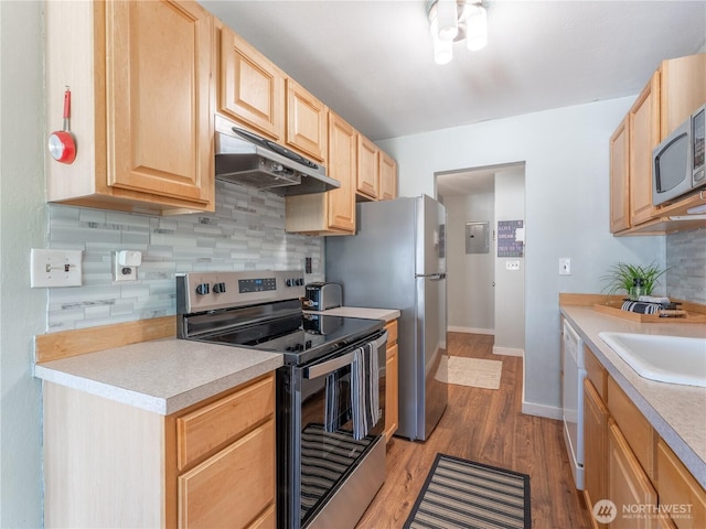 10 S Cove Ave Unit 21, Wenatchee, WA 98801 - kitchen with stainless steel appliances, under cabinet range hood, light brown cabinetry, light countertops, and decorative backsplash