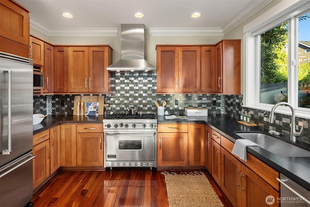 2542 12th Ave W, Seattle, WA 98119 - kitchen with high end appliances, wall chimney range hood, dark countertops, brown cabinetry, and ornamental molding
