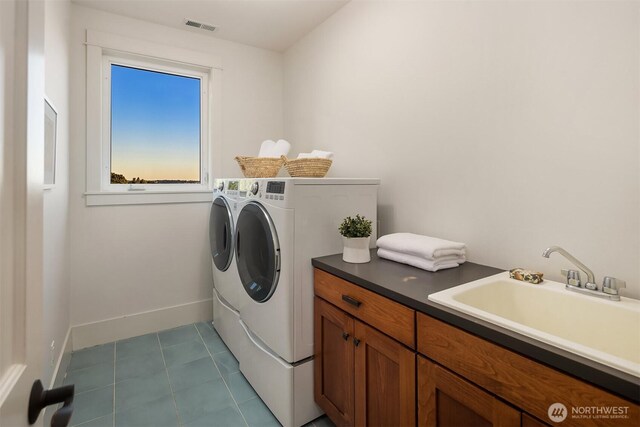 2542 12th Ave W, Seattle, WA 98119 - laundry room featuring washing machine and dryer, cabinet space, and tile patterned floors