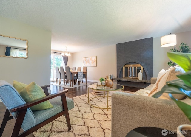 1638 Index Ave SE, Renton, WA 98058 - living room with a chandelier, wood finished floors, a textured ceiling, and a fireplace