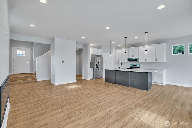 608B Deeded Ln SW, Orting, WA 98360 - kitchen with stainless steel appliances, light countertops, recessed lighting, white cabinetry, and light wood-style flooring