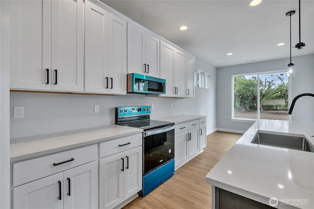 608B Deeded Ln SW, Orting, WA 98360 - kitchen featuring stainless steel microwave, range with electric stovetop, light wood-type flooring, white cabinetry, and pendant lighting