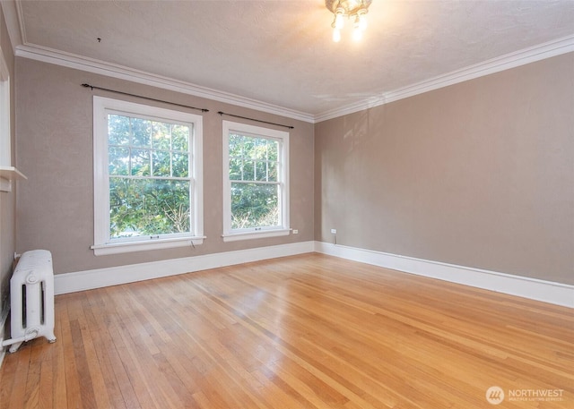 720 6th Ave Unit 206, Tacoma, WA 98405 - spare room featuring radiator heating unit, light wood-style floors, and crown molding