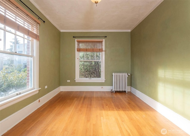 720 6th Ave Unit 206, Tacoma, WA 98405 - unfurnished room featuring radiator heating unit, light wood-type flooring, and ornamental molding