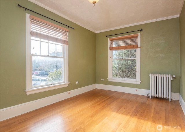 720 6th Ave Unit 206, Tacoma, WA 98405 - empty room with radiator, healthy amount of natural light, light wood-type flooring, and crown molding