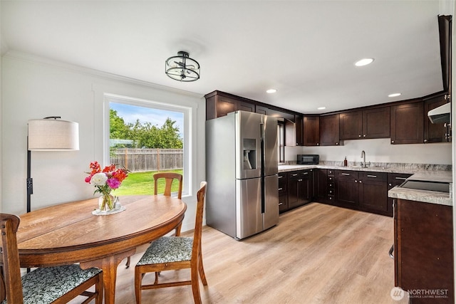 17371 Dunbar Rd, Mount Vernon, WA 98273 - kitchen with black appliances, dark brown cabinetry, ornamental molding, light countertops, and light wood-style floors