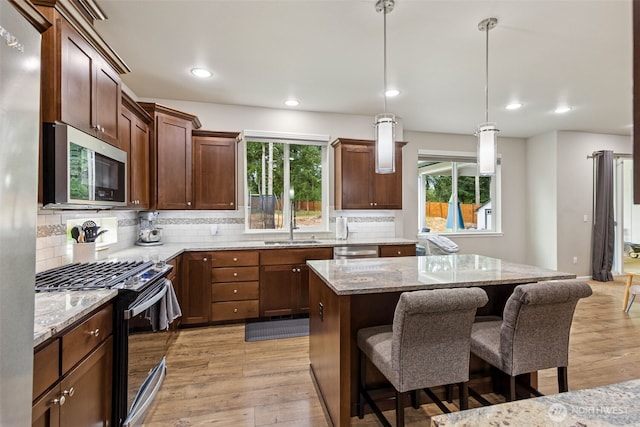 4921 Skylark St NE, Lacey, WA 98516 - kitchen with stainless steel appliances, a center island, light wood finished floors, light stone countertops, and recessed lighting