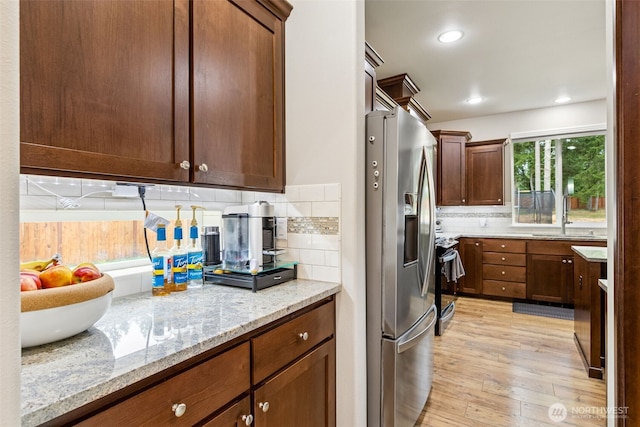 4921 Skylark St NE, Lacey, WA 98516 - kitchen featuring appliances with stainless steel finishes, light wood-type flooring, backsplash, light stone countertops, and recessed lighting