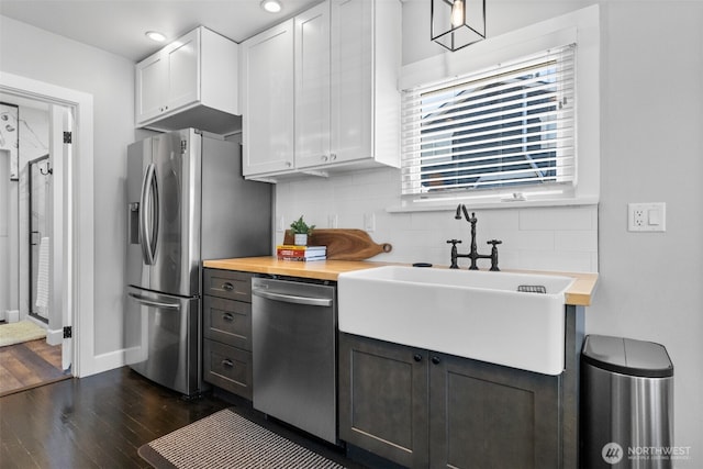 709 7th St SW, Puyallup, WA 98371 - kitchen featuring appliances with stainless steel finishes, dark wood finished floors, decorative backsplash, butcher block countertops, and white cabinetry