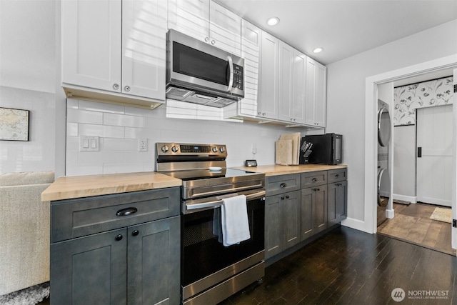 709 7th St SW, Puyallup, WA 98371 - kitchen with appliances with stainless steel finishes, wooden counters, dark wood-style flooring, decorative backsplash, and recessed lighting