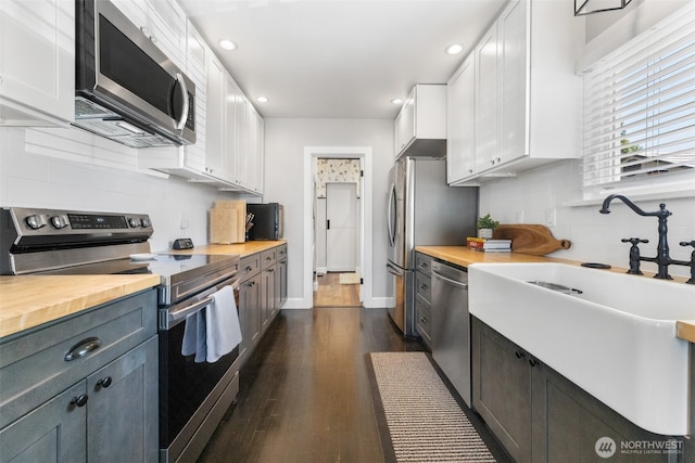 709 7th St SW, Puyallup, WA 98371 - kitchen featuring appliances with stainless steel finishes, butcher block counters, white cabinets, backsplash, and recessed lighting