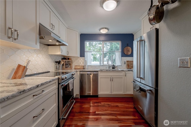 916 N 165th St Unit 7, Shoreline, WA 98133 - kitchen with appliances with stainless steel finishes, under cabinet range hood, dark wood finished floors, tasteful backsplash, and white cabinets