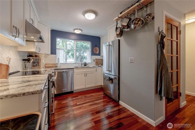 916 N 165th St Unit 7, Shoreline, WA 98133 - kitchen featuring appliances with stainless steel finishes, under cabinet range hood, decorative backsplash, dark wood-type flooring, and white cabinets