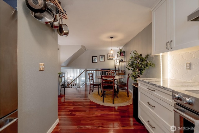 916 N 165th St Unit 7, Shoreline, WA 98133 - kitchen with stainless steel electric stove, decorative backsplash, wall chimney range hood, dark wood-style floors, and white cabinetry