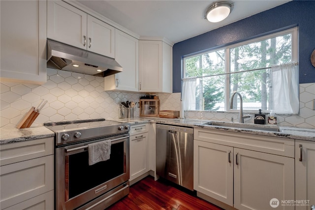 916 N 165th St Unit 7, Shoreline, WA 98133 - kitchen featuring appliances with stainless steel finishes, under cabinet range hood, white cabinets, tasteful backsplash, and dark wood-style floors