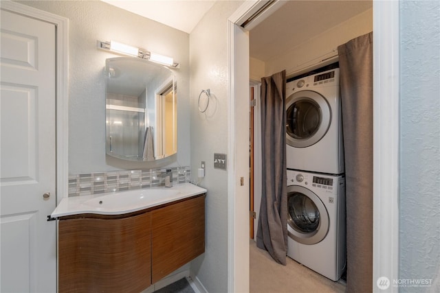 916 N 165th St Unit 7, Shoreline, WA 98133 - bathroom featuring stacked washer / dryer, vanity, decorative backsplash, and a textured wall