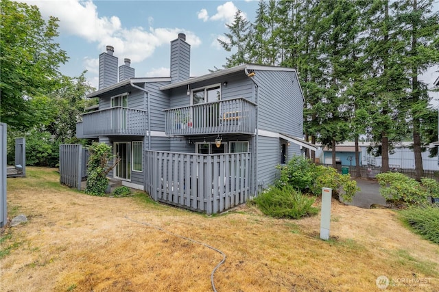 916 N 165th St Unit 7, Shoreline, WA 98133 - rear view of house featuring a balcony, a lawn, and a chimney