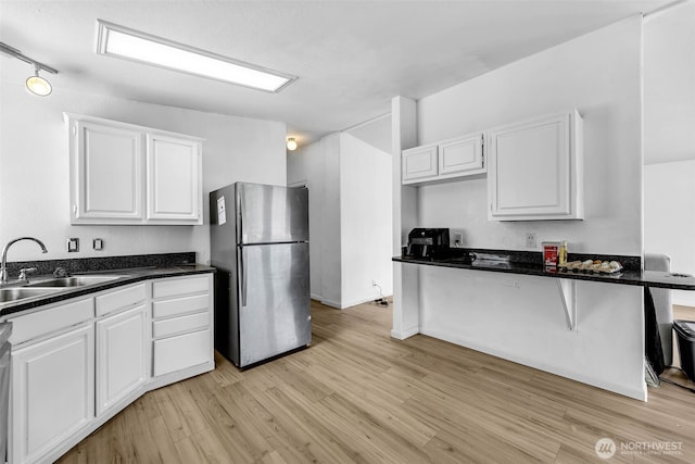 241B Foster Creek Rd, Toledo, WA 98591 - kitchen with freestanding refrigerator, light wood finished floors, white cabinets, and dark countertops
