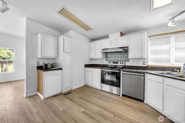 241B Foster Creek Rd, Toledo, WA 98591 - kitchen featuring stainless steel appliances, extractor fan, vaulted ceiling, light wood-type flooring, and dark countertops