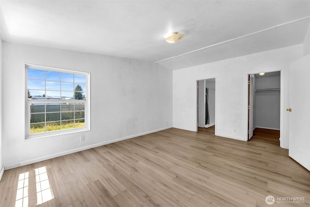241B Foster Creek Rd, Toledo, WA 98591 - unfurnished bedroom with light wood-type flooring, a walk in closet, and a closet
